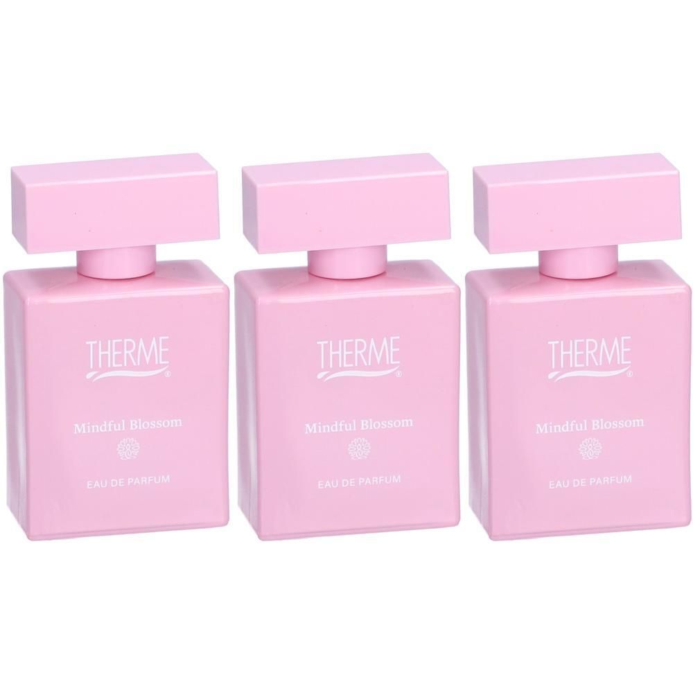 Trois flacons roses d'eau de parfum avec inscription argentée 'THERME Mindful Blossom'.