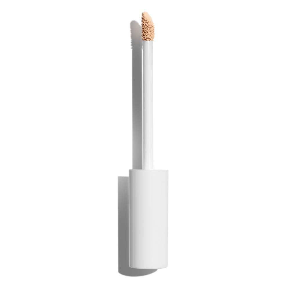 Un applicateur de correcteur avec capuchon blanc et flacon transparent, applicateur sorti.