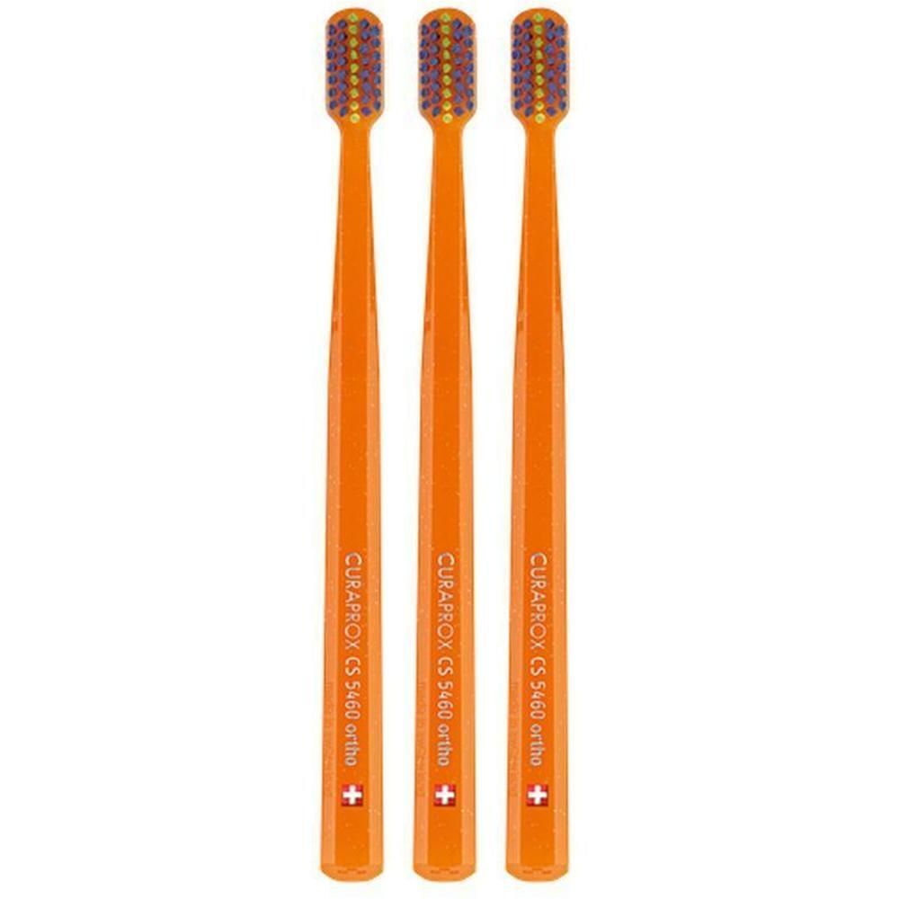 Trois brosses à dents orange avec poils violets, inscription "CURAPROX CS 5460 ortho".