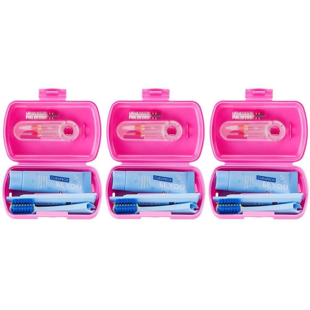 Trois trousses de voyage ouvertes avec brosses à dents, dentifrice et brossettes interdentaires roses.