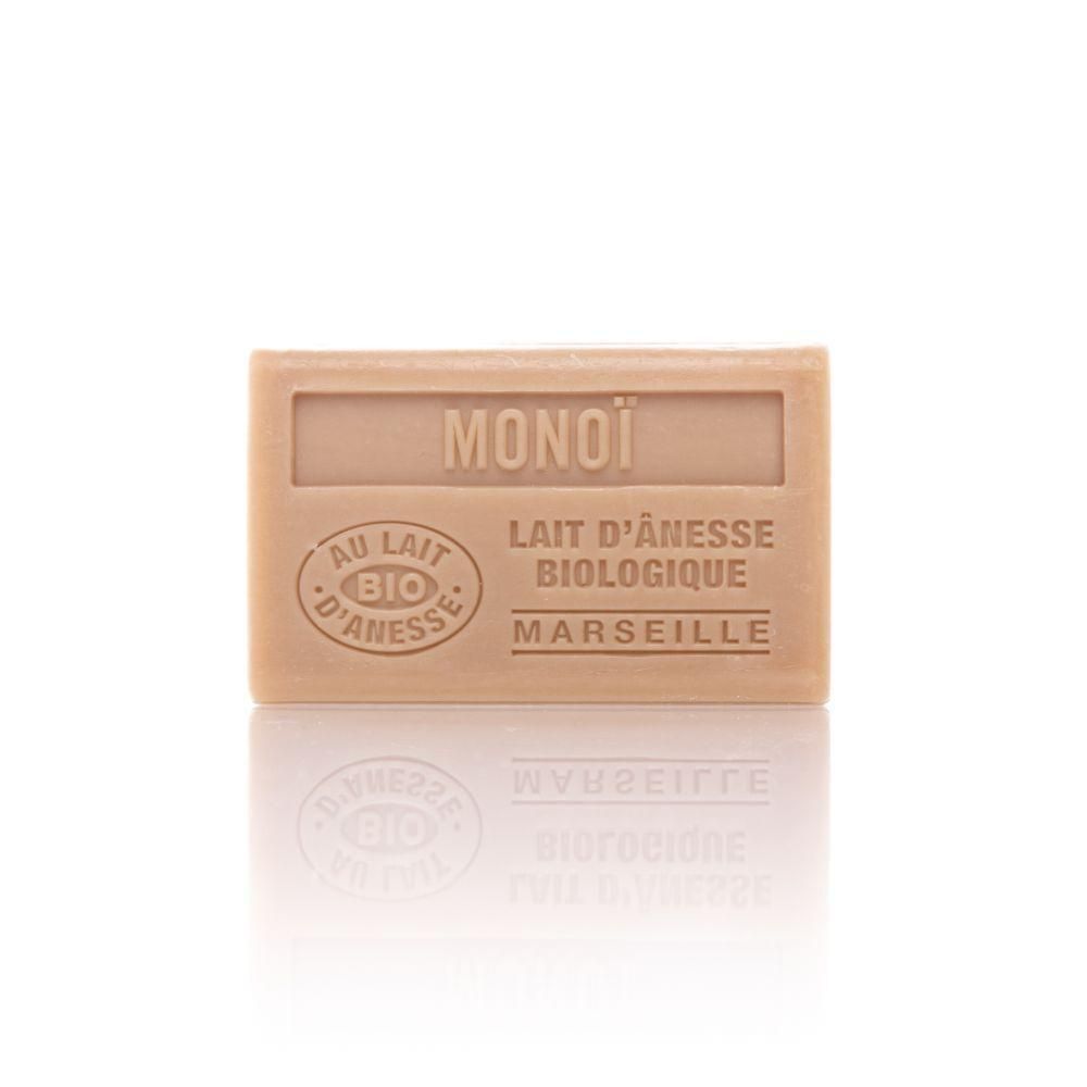 Un pain de savon rectangulaire marqué MONOÏ, AU LAIT BIO D'ANESSE, BIOLOGIQUE, MARSEILLE.