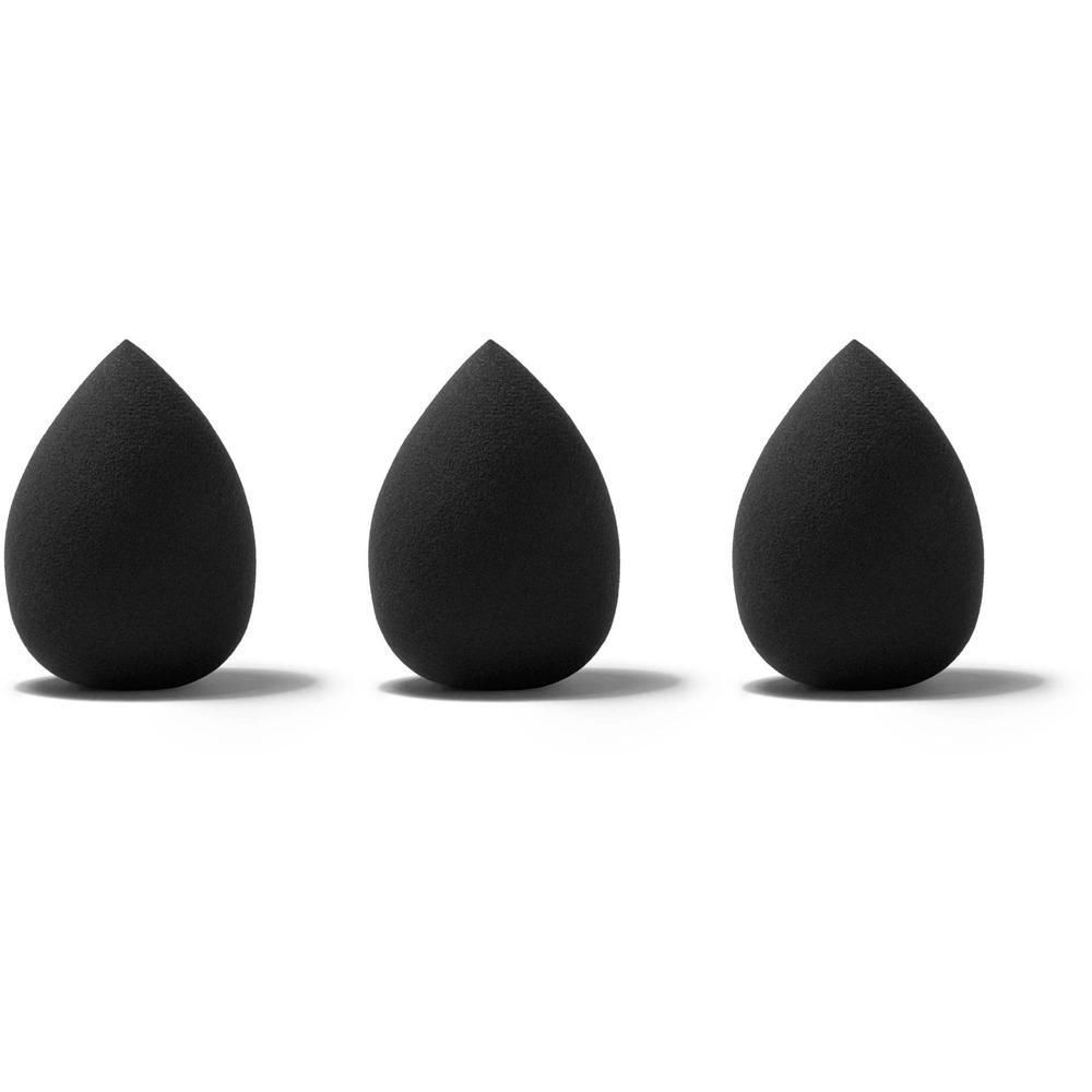 Trois éponges de maquillage noires en forme de goutte d'eau, alignées sur fond blanc.