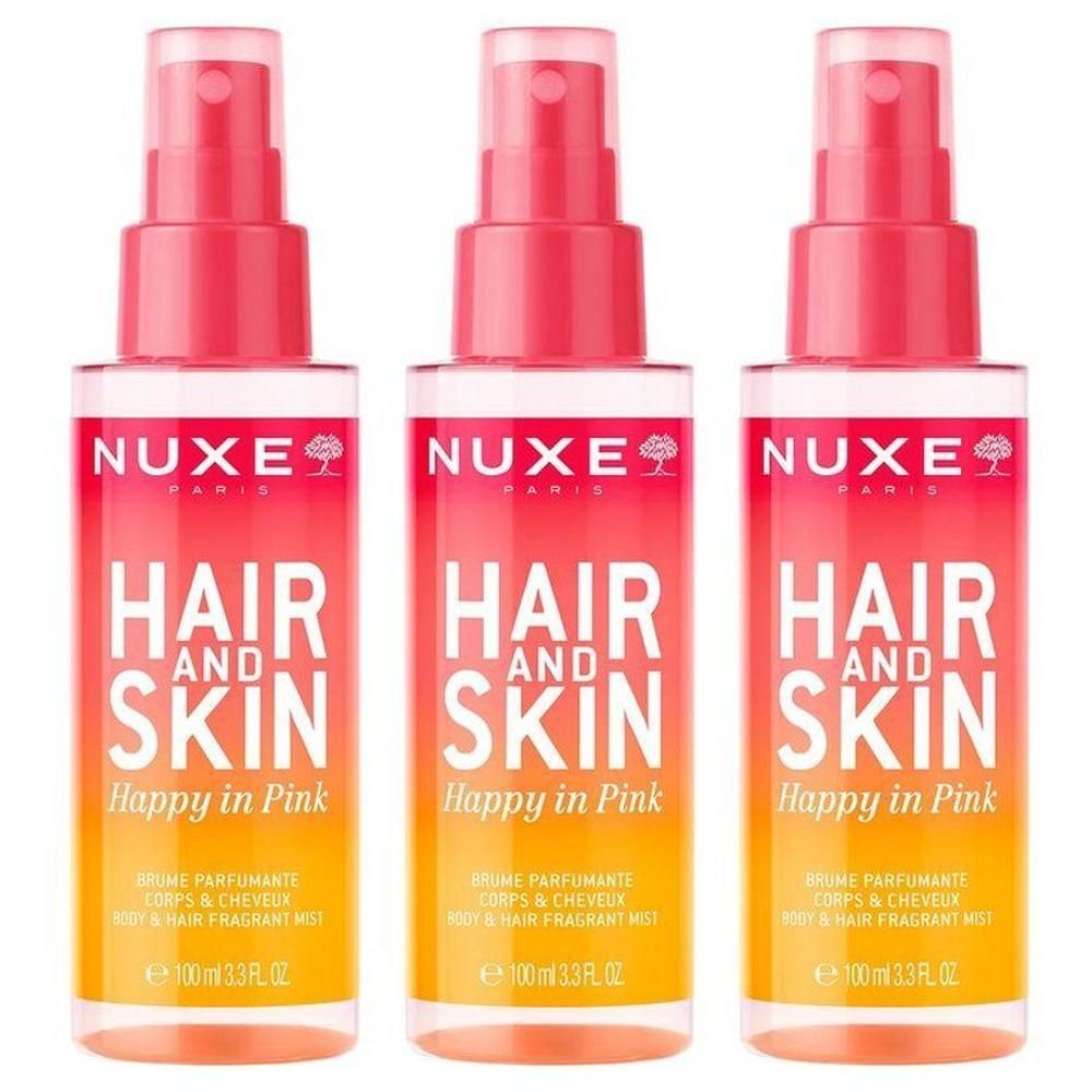 Trois flacons vaporisateurs Nuxe Cheveux et Peau, parfum Happy in Pink. Flacons transparents avec dégradé rose et orange.