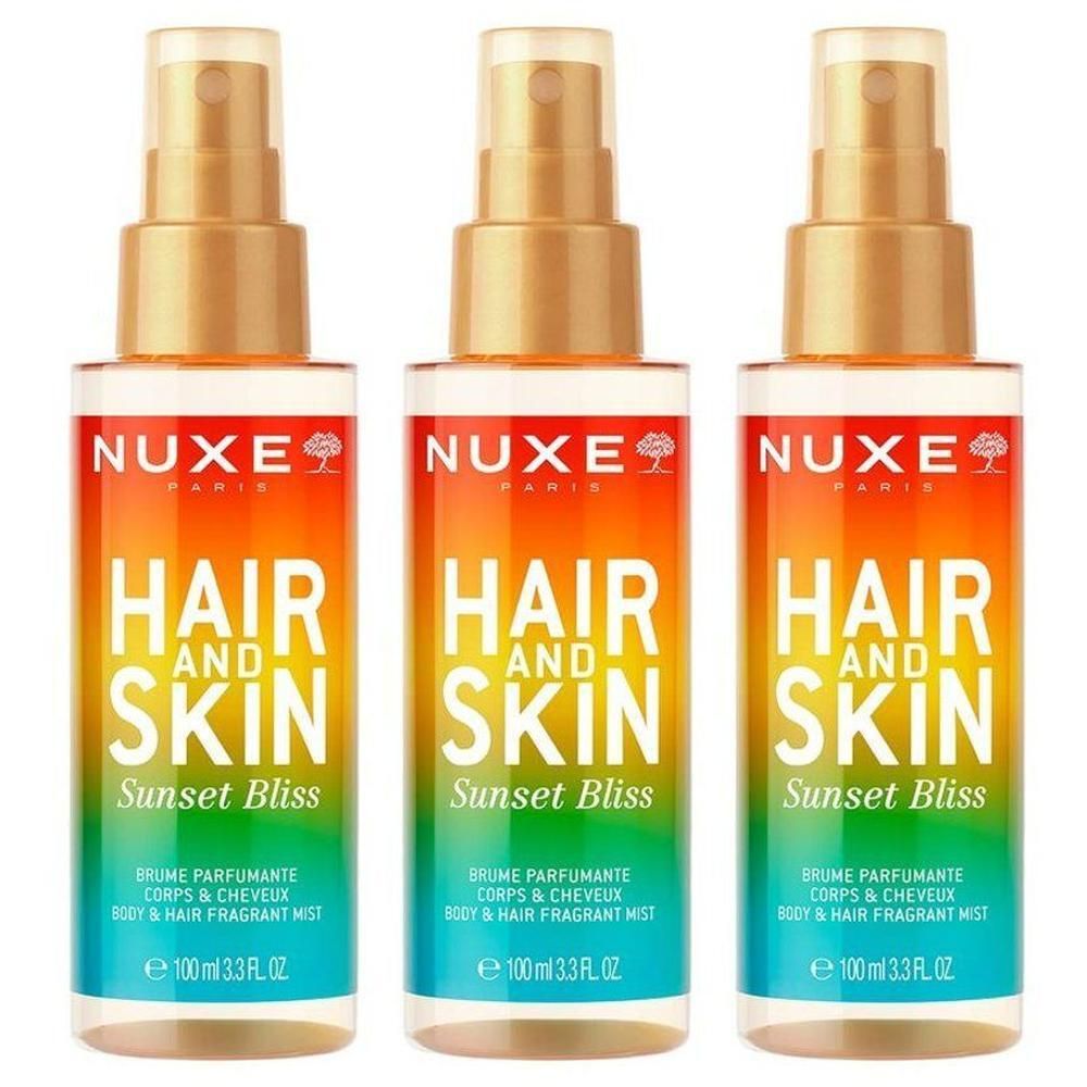Drie Nuxe haar- en lichaamssprays met gouden spuitkoppen en kleurrijke etiketten.