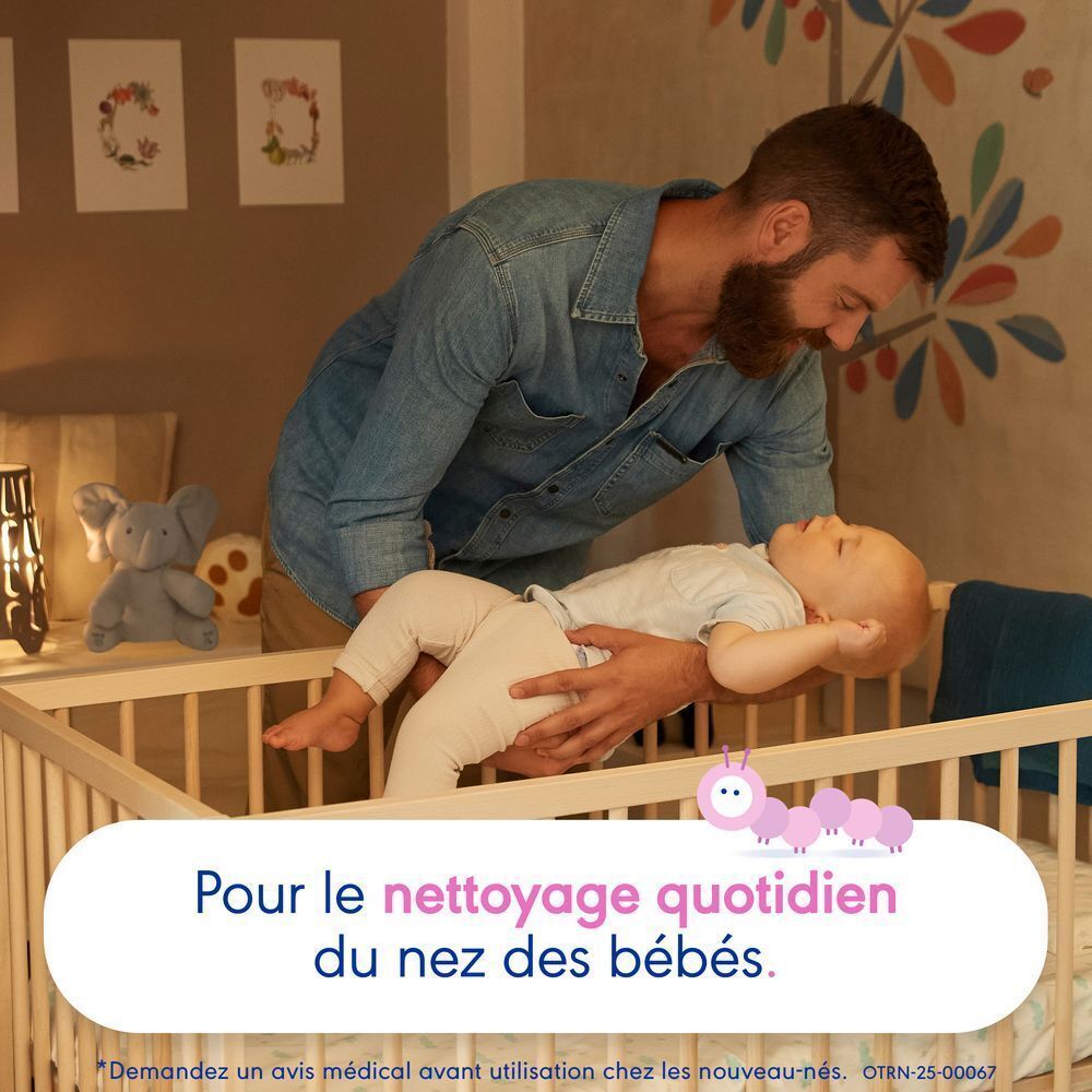 Père tenant un bébé au-dessus du lit. OtriCare Baby pour le nettoyage nasal quotidien.