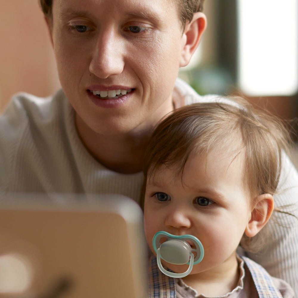 Vader met baby die een Philips Avent speentje draagt.