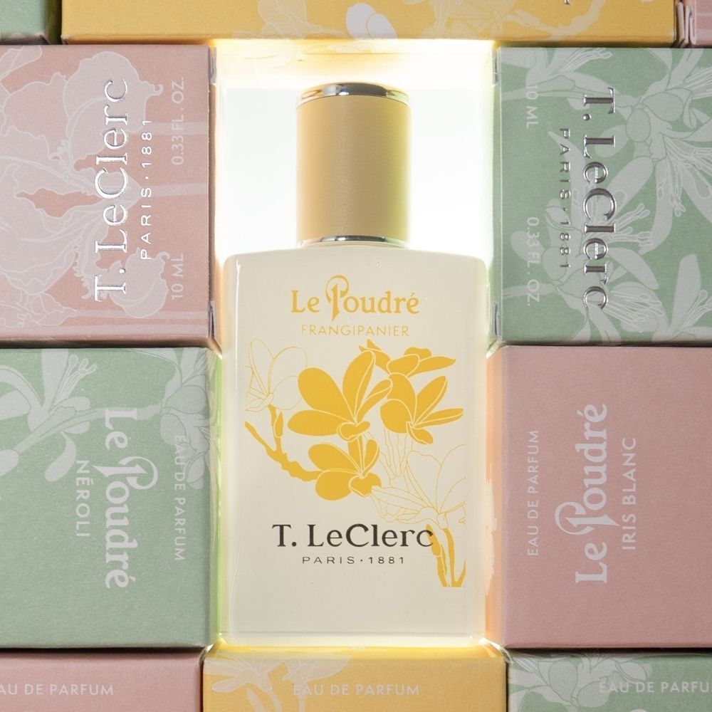 Een witte flacon met gele bloemen, omringd door kleurrijke productverpakkingen.