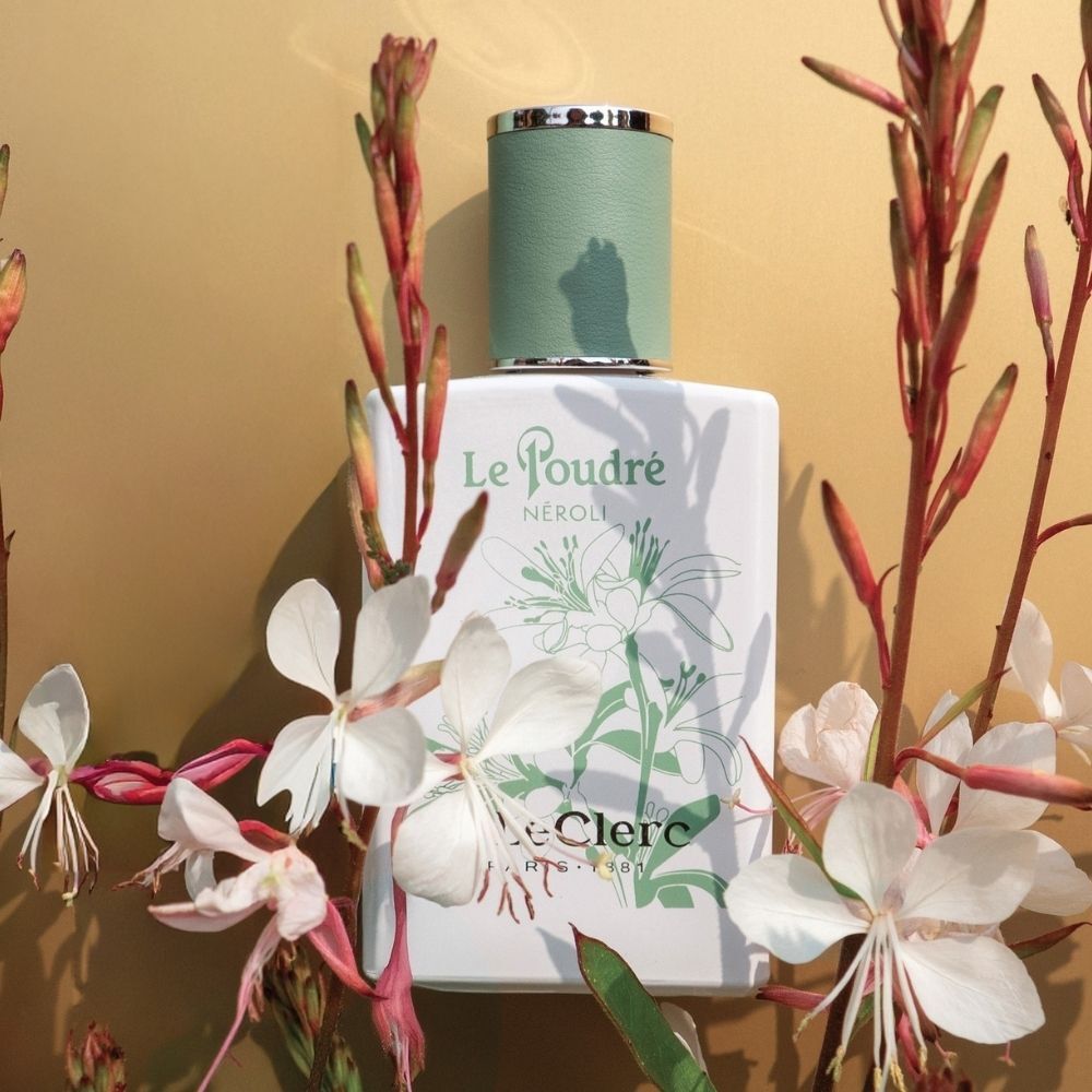 T. LeClerc Parfum Le Poudré Néroli omringd door nerolibloesems en takken.