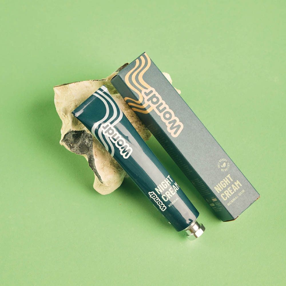 Tube et emballage de WONDR Night Cream sur fond vert.