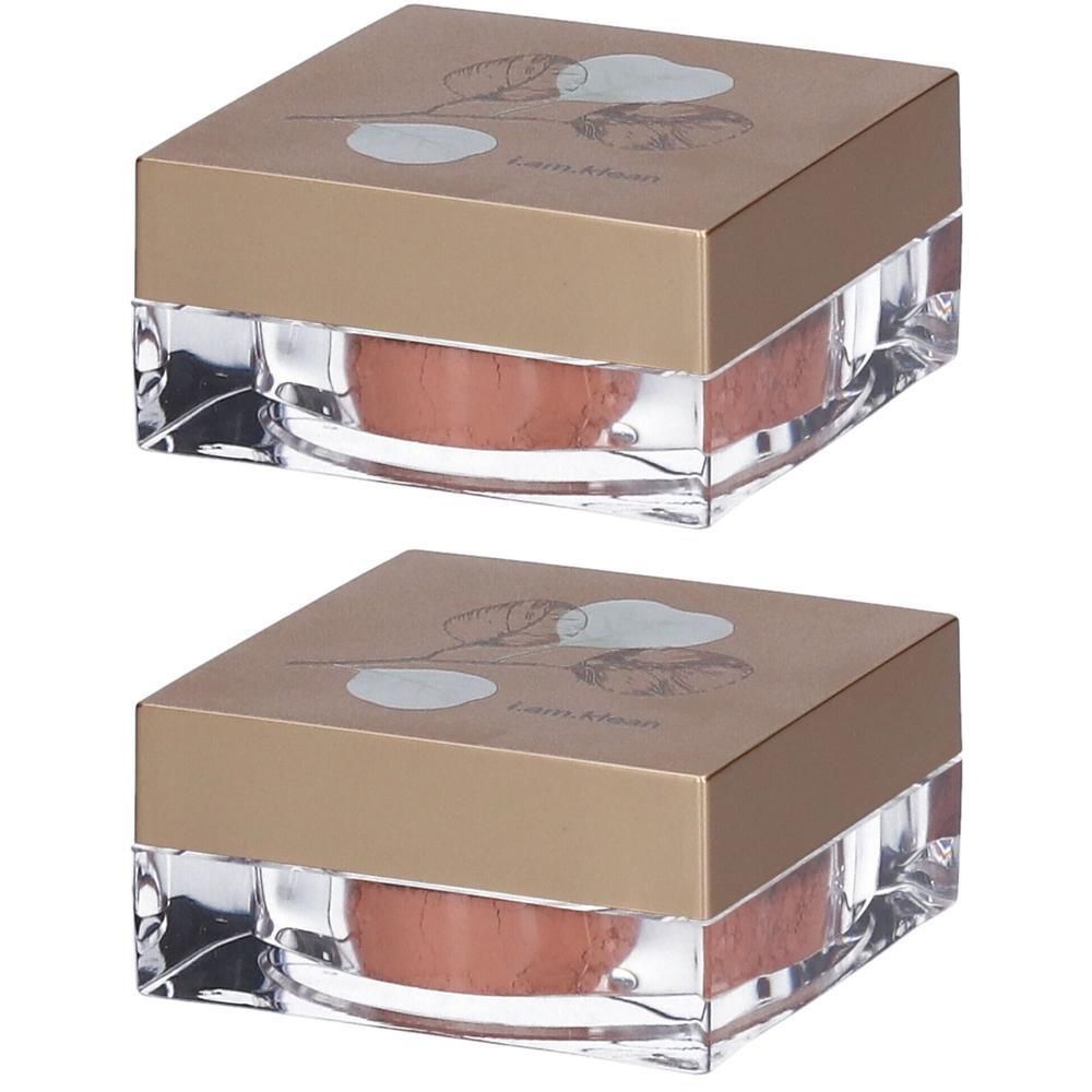 Twee potjes los minerale blush in perzikkleur. Duidelijke glazen basis met goudkleurig deksel en bloemmotief.