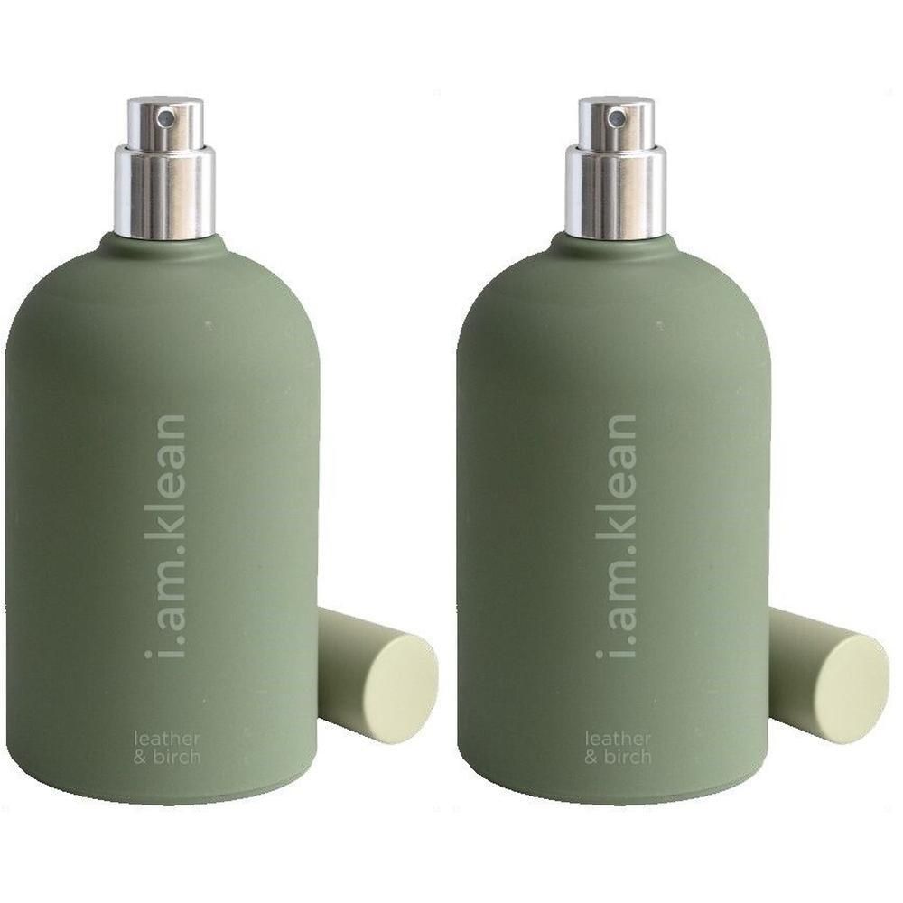 Twee groene spuitflessen met zilveren verstuivers en doppen. Tekst op de flessen: i.am.klean, leather & birch.