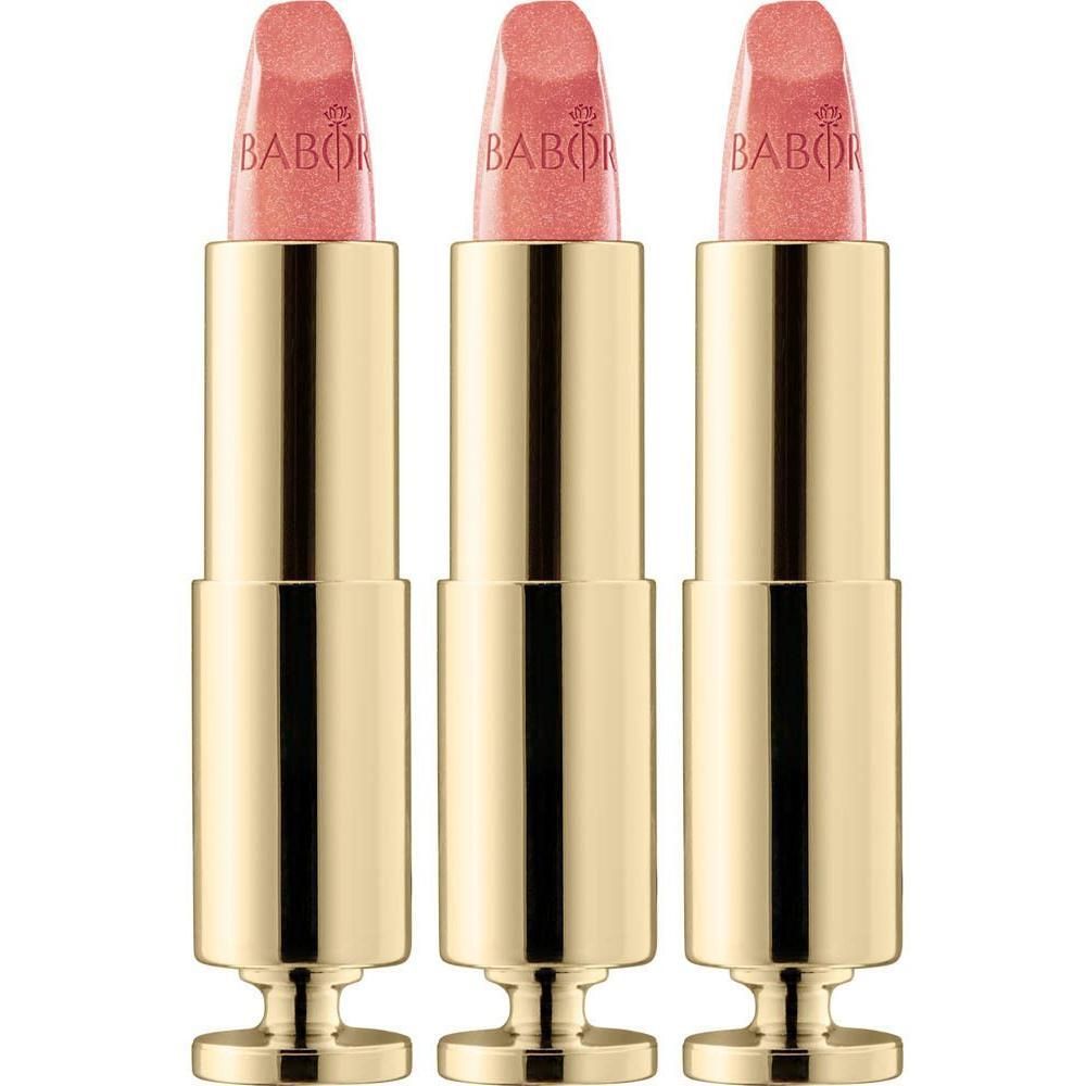 Trois rouges à lèvres dorés avec une texture rose scintillante.