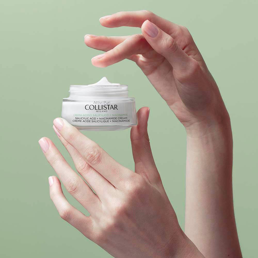 Des mains tenant un pot de Crème Acide Salicylique + Niacinamide Collistar.