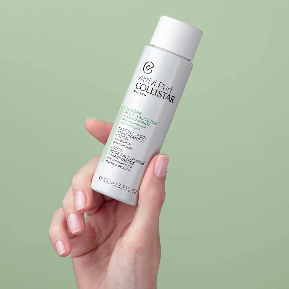 Une main tenant un flacon de Lotion Acide Salicylique + Niacinamide Collistar.