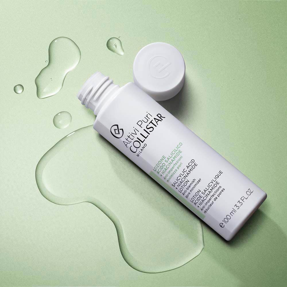 Een fles Collistar Salicylzuur + Niacinamide Lotion met gemorste vloeistof en open dop.