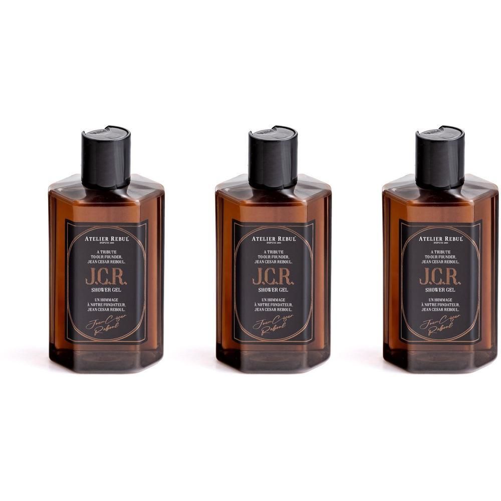 Trois flacons de gel douche Atelier Rebul J.C.R. avec étiquettes brunes et bouchons noirs.
