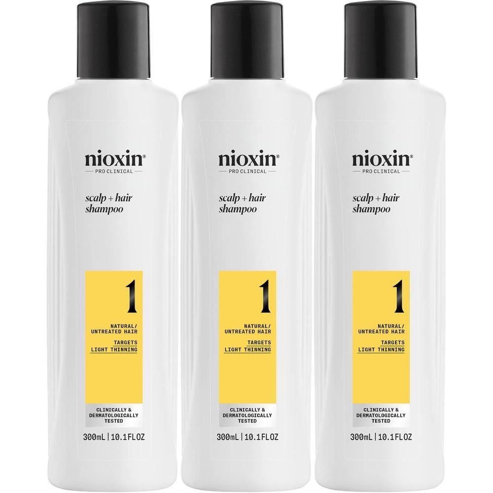 Trois flacons blancs Nioxin avec étiquette jaune, numéro 1, pour cheveux naturels non traités.