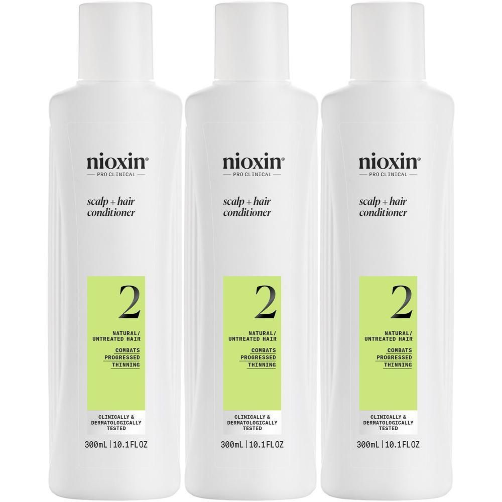 Trois bouteilles blanches de revitalisant Nioxin Système 2, étiquetées 'Scalp + Hair Conditioner' et 'Natural/Untreated Hair'.