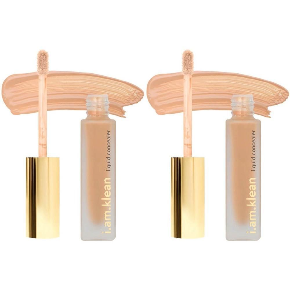 Twee flesjes vloeibare concealer met gouden doppen en applicators, met daarnast aangebrachte swatches.