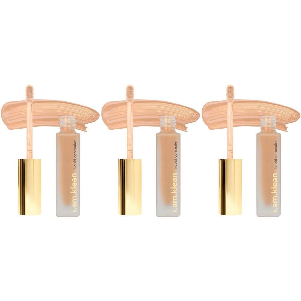 Drie flesjes i.am.klean Liquid Concealer met gouden doppen en applicators, met kleurstalen ernaast.