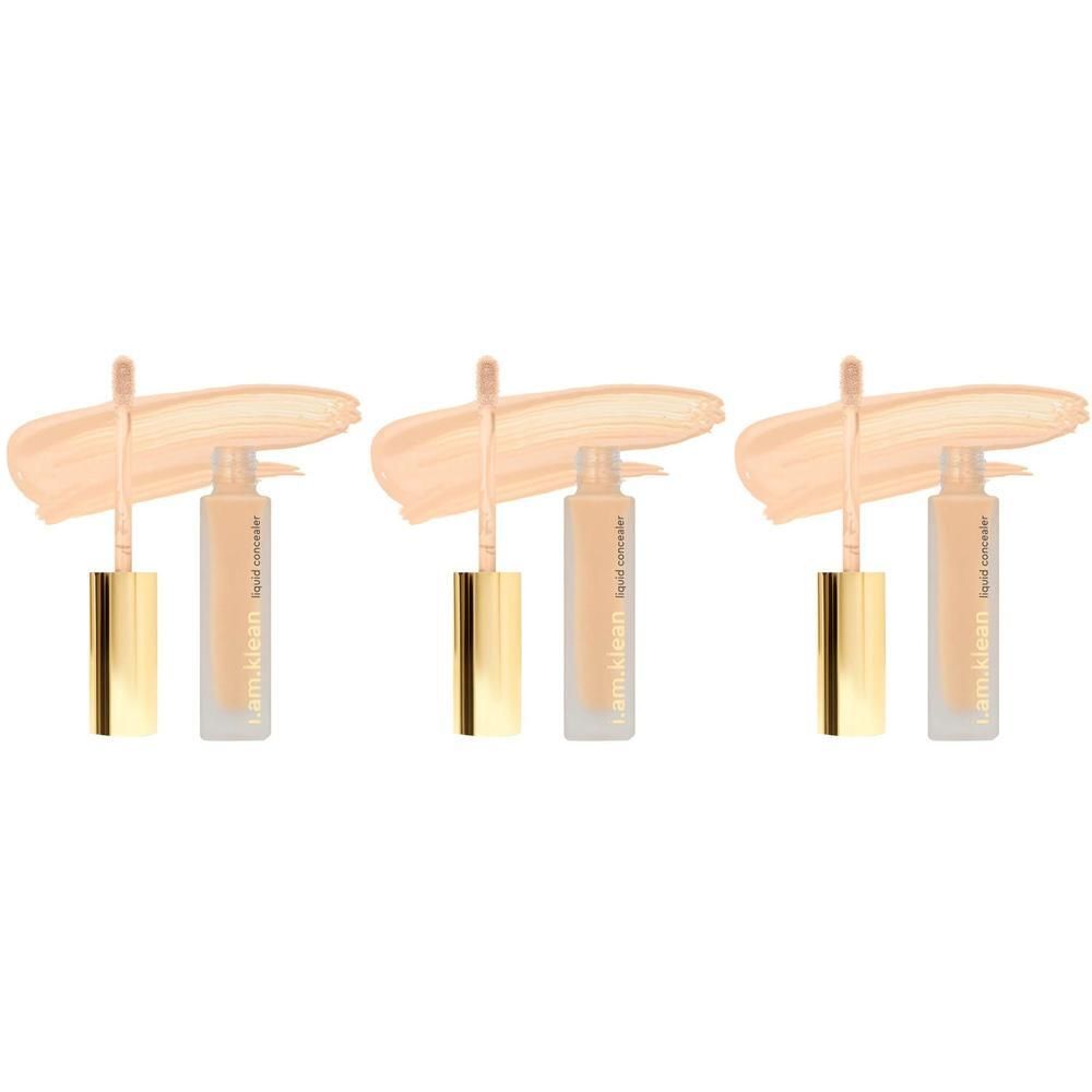 Trois flacons de correcteur liquide avec capuchons dorés et applicateurs, accompagnés de touches crémeuses.