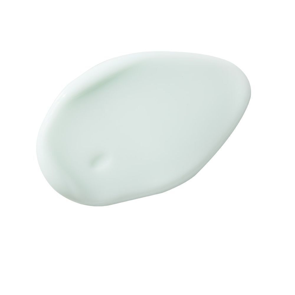Een vlek lichtgroene crème op een witte achtergrond.
