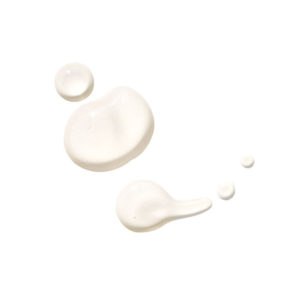 Meerdere druppels witte vloeistof op een witte achtergrond.