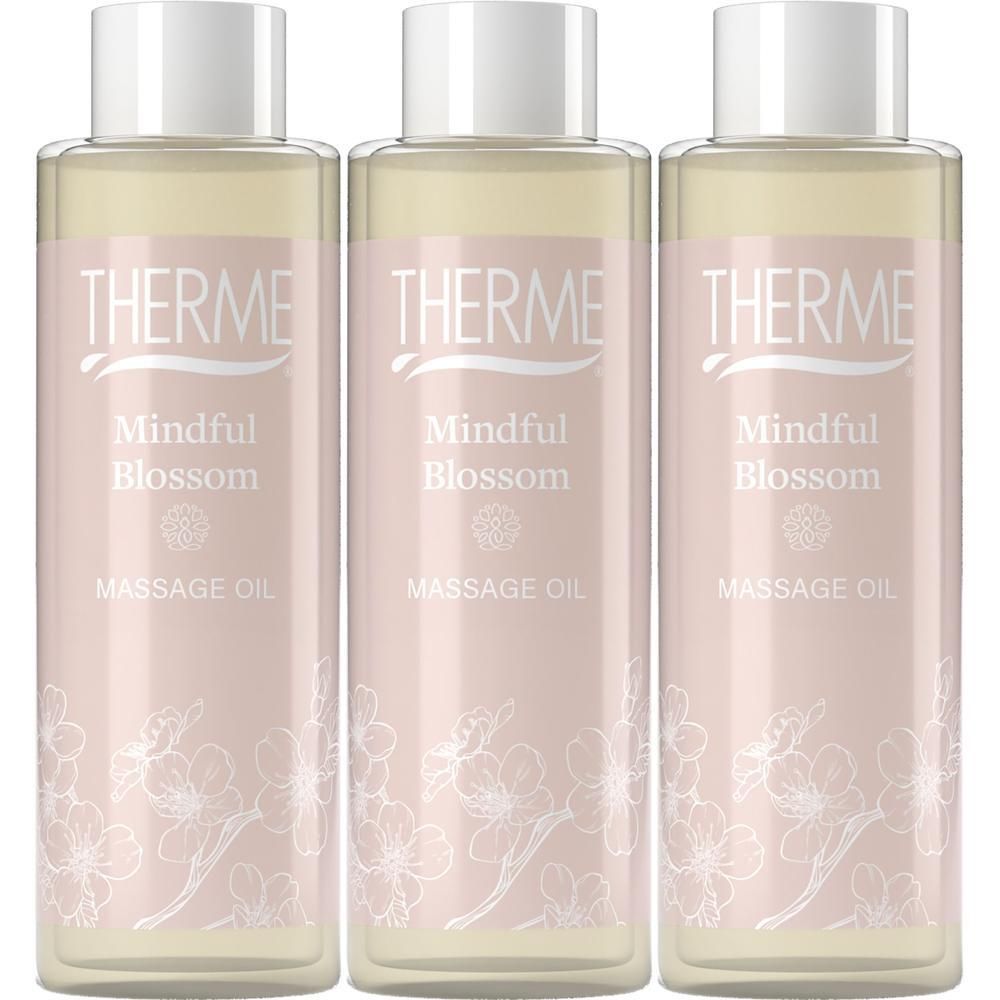 Trois bouteilles d'huile de massage Therme Mindful Blossom avec bouchons blancs et étiquettes roses.