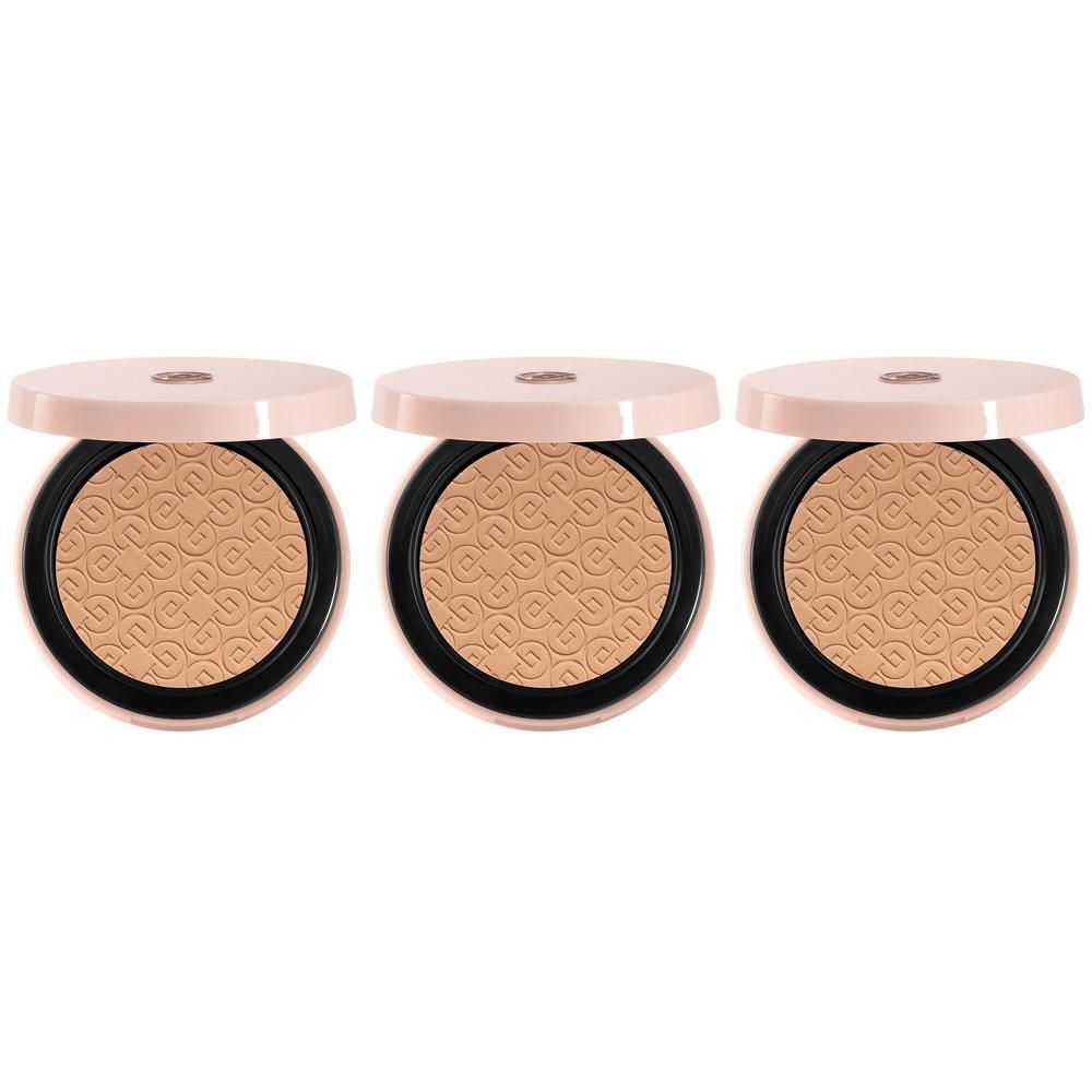 Drie open compactpoederdoosjes, lichtbeige poeder met reliëfpatroon.