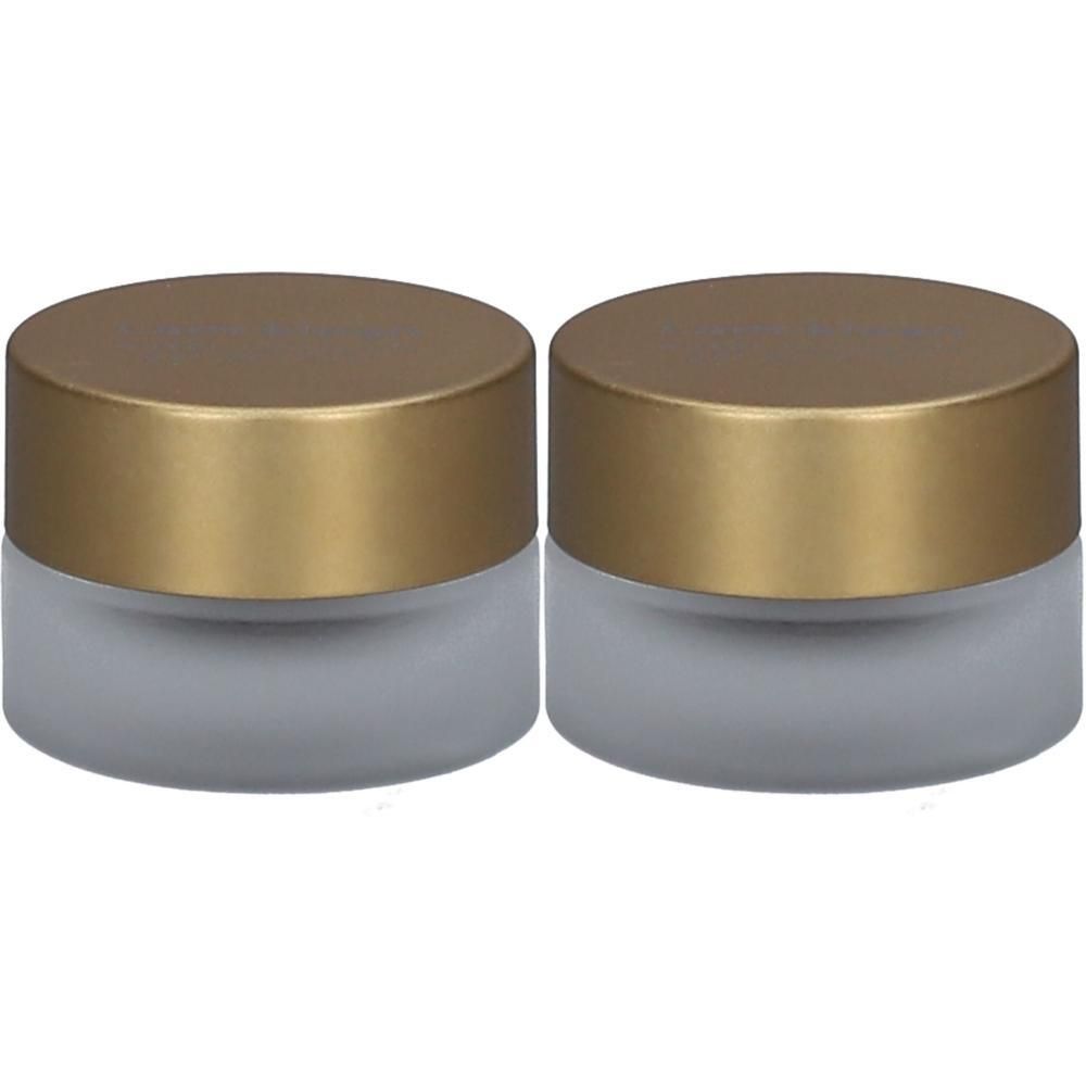 Twee kleine potjes van matgrijs glas met gouden deksels.