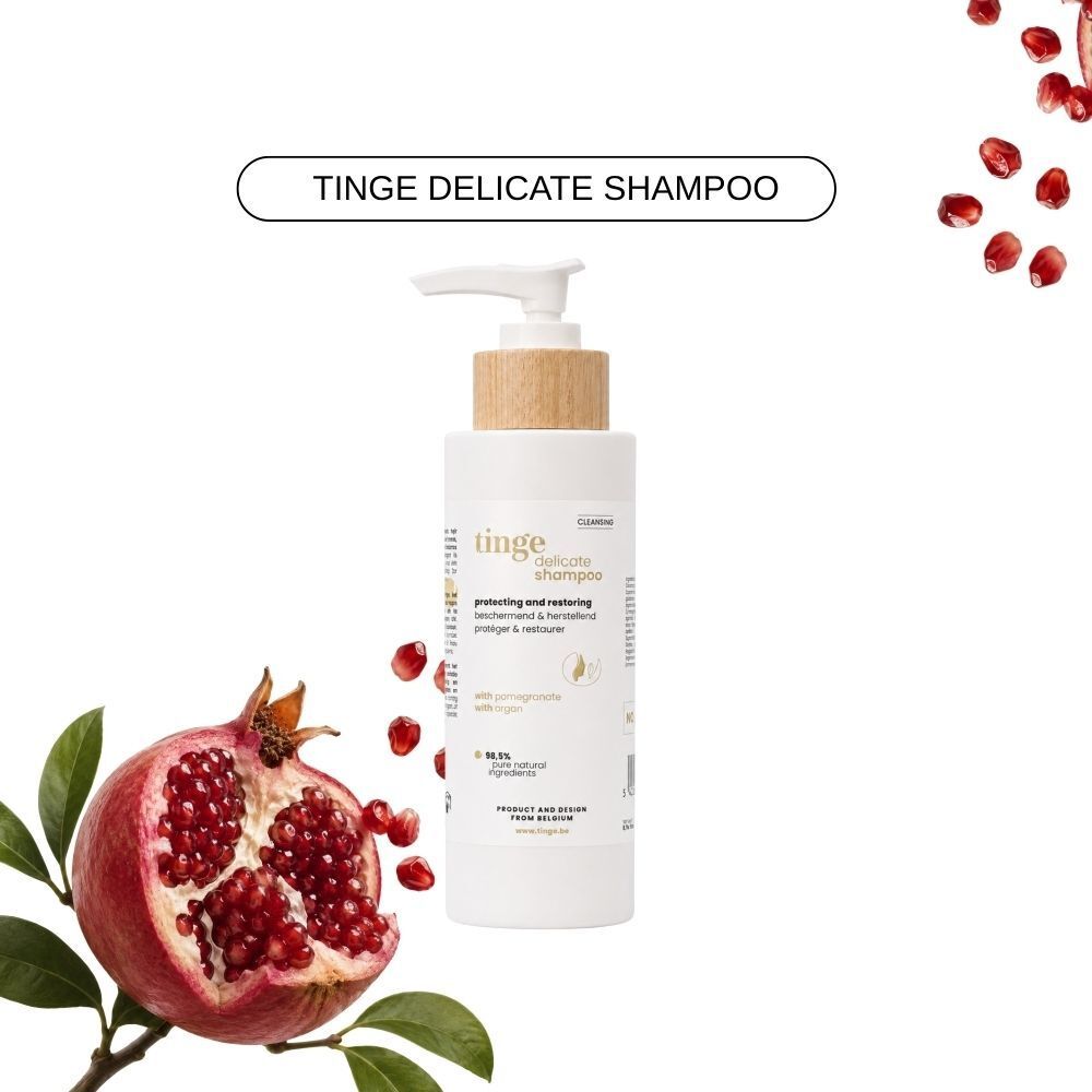 Fles Tinge Delicate Shampoo met granaatappelstukjes en granaatappeltak.