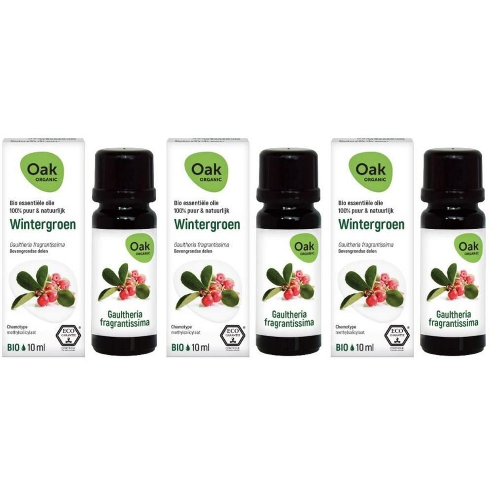 Quatre flacons d'huile essentielle bio Oak Wintergreen avec baies et feuilles.