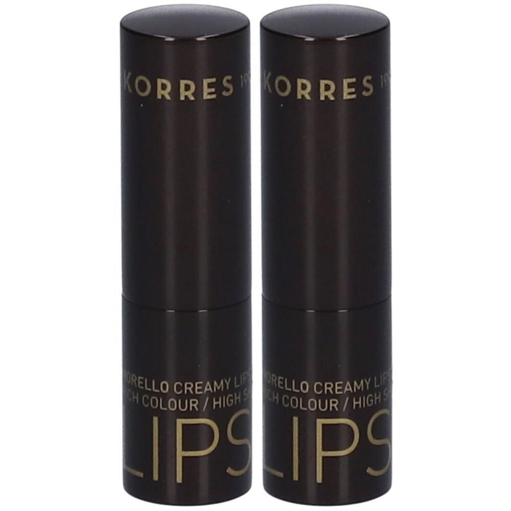 Twee Korres lippenstiften in donkere verpakking met gouden belettering.