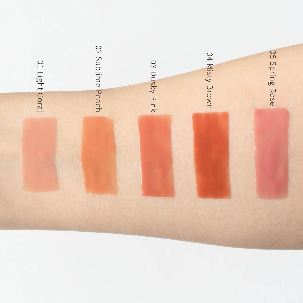 Cinq échantillons de couleur de Couleurs de Noir Instant Gloss Lip Maximizer sur peau : 02 Sublime Peach est le deuxième en partant de la gauche.