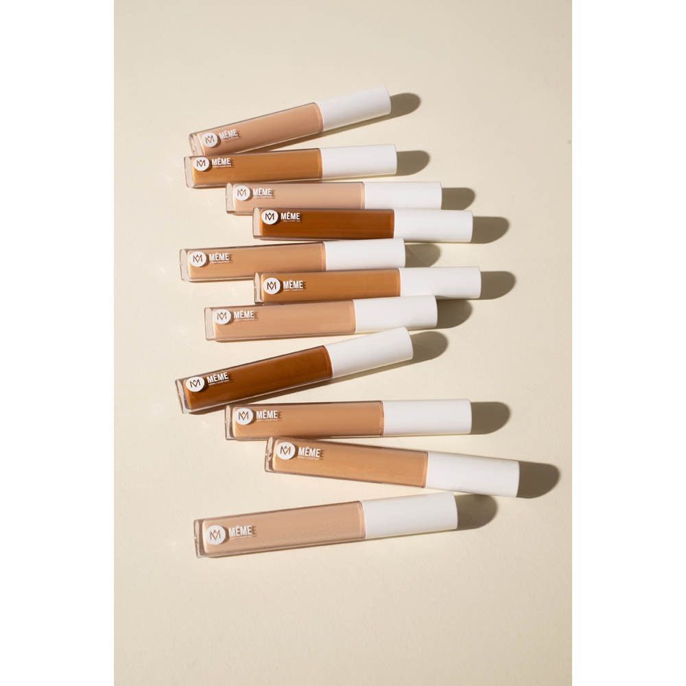 Meerdere flesjes Même Correcteur Fluide, gerangschikt in een curve.