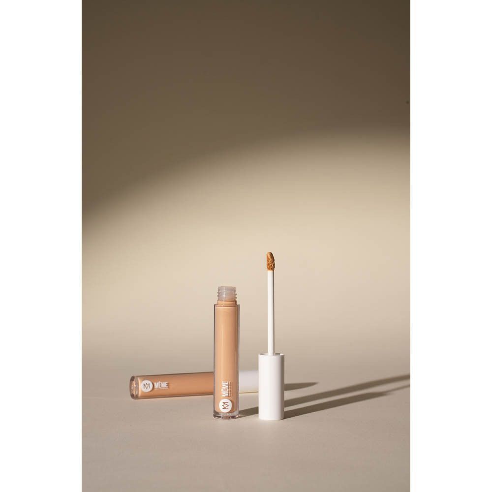 Deux flacons de Même Correcteur Fluide, un ouvert avec applicateur.