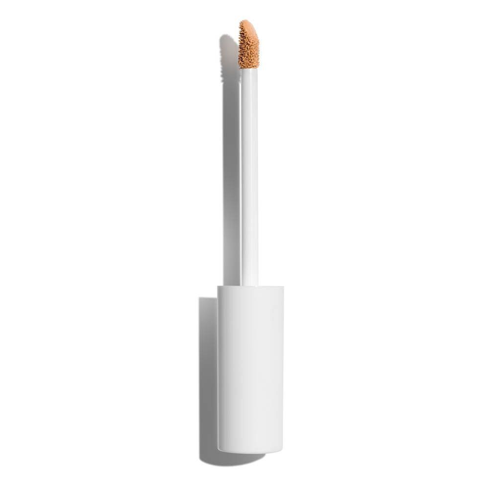 Un applicateur blanc avec du liquide beige, sorti d'un correcteur fluide.