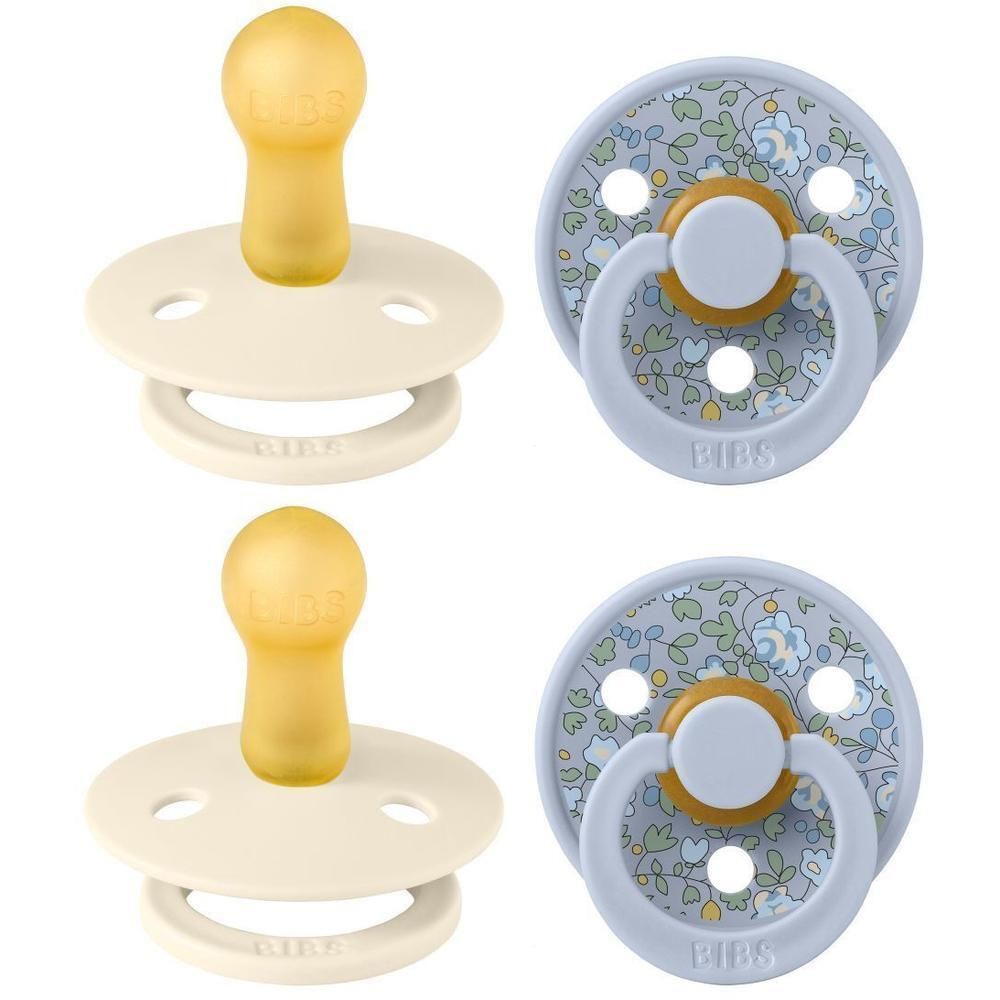 Twee BIBS spenen: één crème met gele speen, één blauwe met bloemenprint en gele speen.