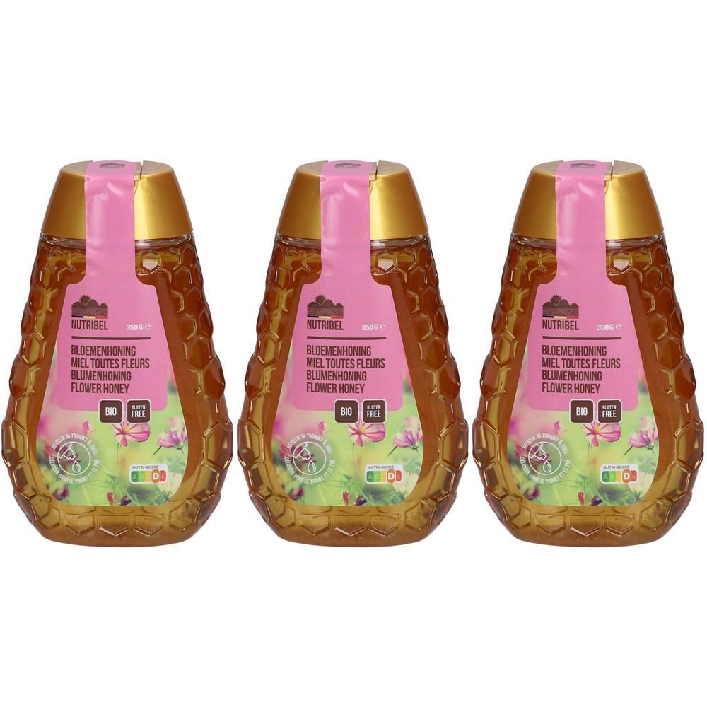 Trois bouteilles de miel toutes fleurs Nutribel avec bouchons dorés et étiquettes roses. Les bouteilles ont une texture en nid d'abeille.