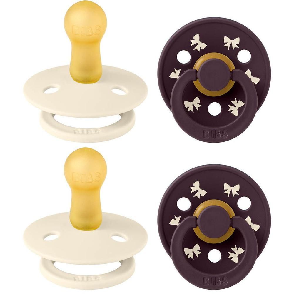 Deux sucettes BIBS : une crème avec tétine jaune et une foncée à motifs nœuds.