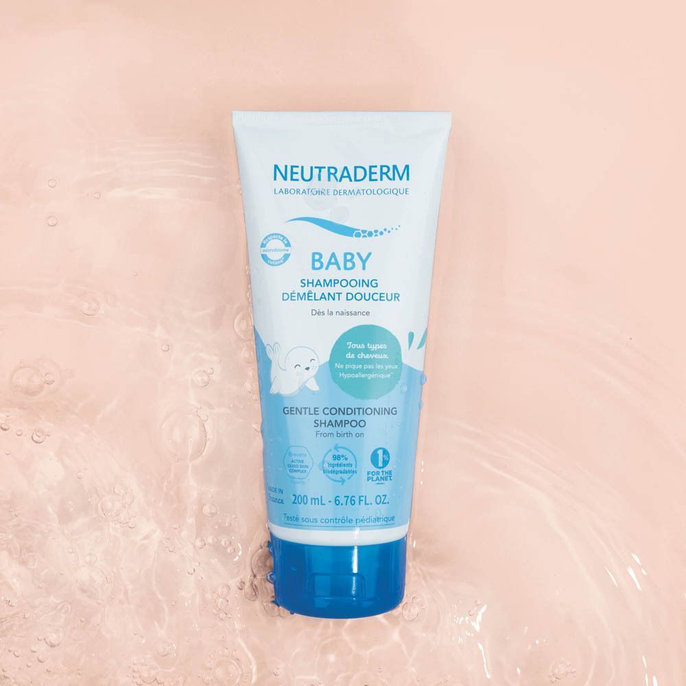 Een flacon Neutraderm Shampooing Démêlant Douceur op een lichte achtergrond met water.