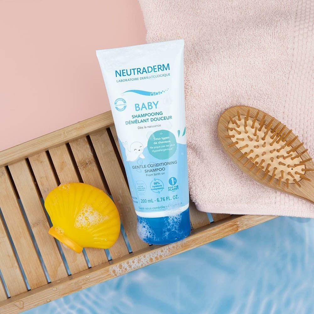 Neutraderm Shampooing Démêlant Douceur op een houten dienblad met badaccessoires.