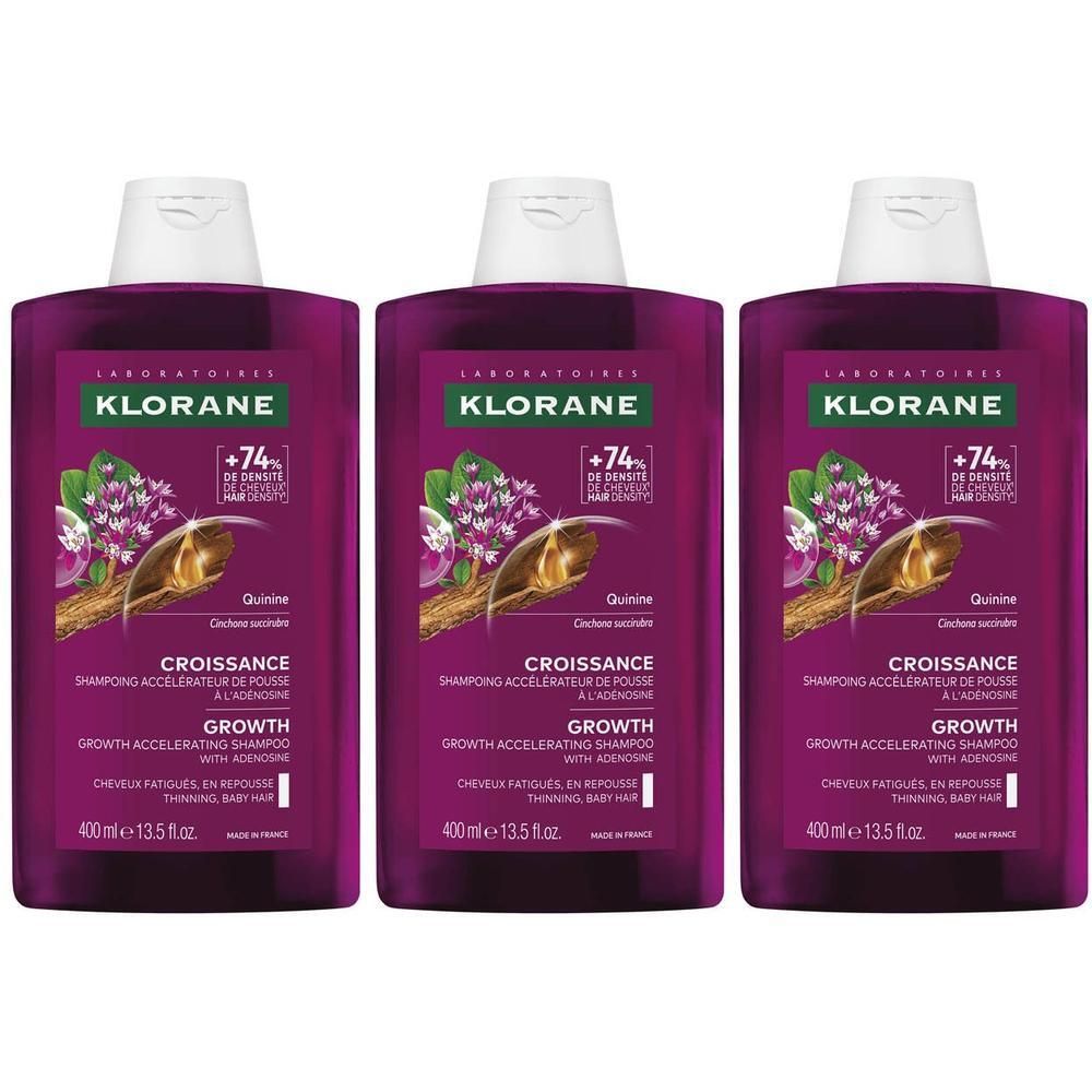Drie Klorane Groei shampoo flessen, paars etiket, witte dop.