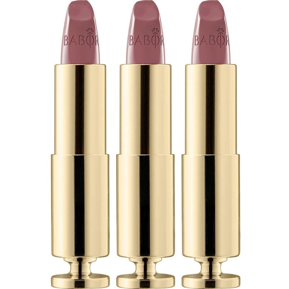 Trois tubes de rouge à lèvres dorés avec un rouge à lèvres rose nude.