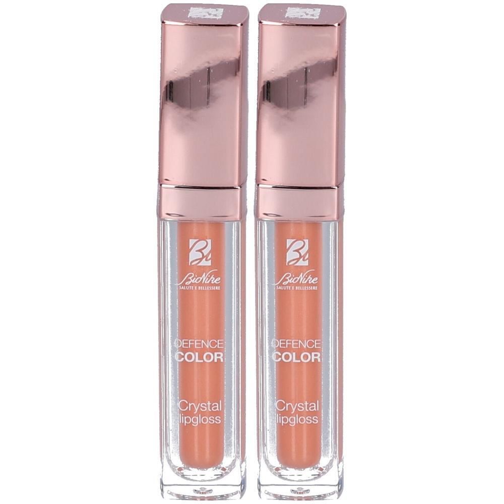 Twee BioNike Defence Color Crystal Lipgloss flesjes in perzikkleur.