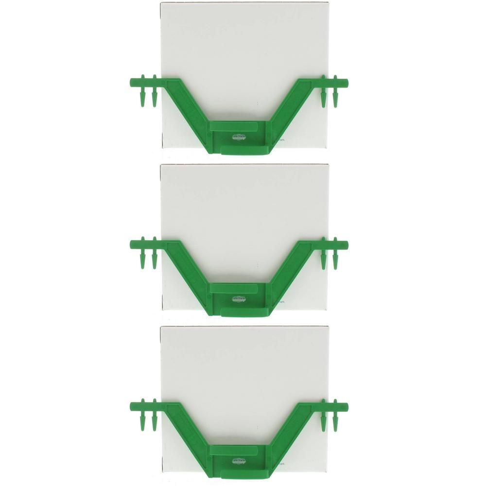Trois supports verts avec deux broches chacun, tenant des carrés blancs.