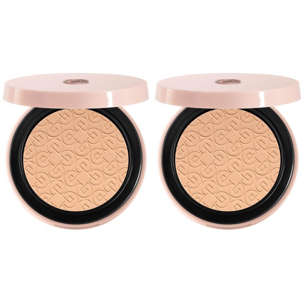 Twee open compactpoederdoosjes met beige poeder en reliëfpatroon.