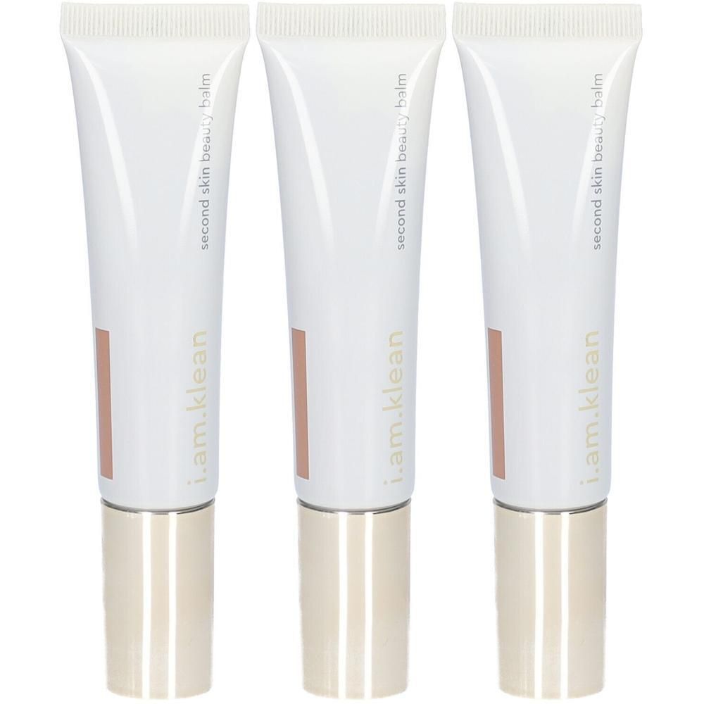 Trois tubes blancs de i.am.klean Second Skin Beauty Balm avec capuchons dorés.