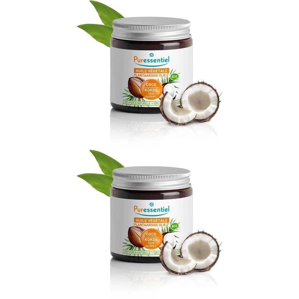 Deux pots d'huile de coco avec moitiés de noix de coco et feuilles.