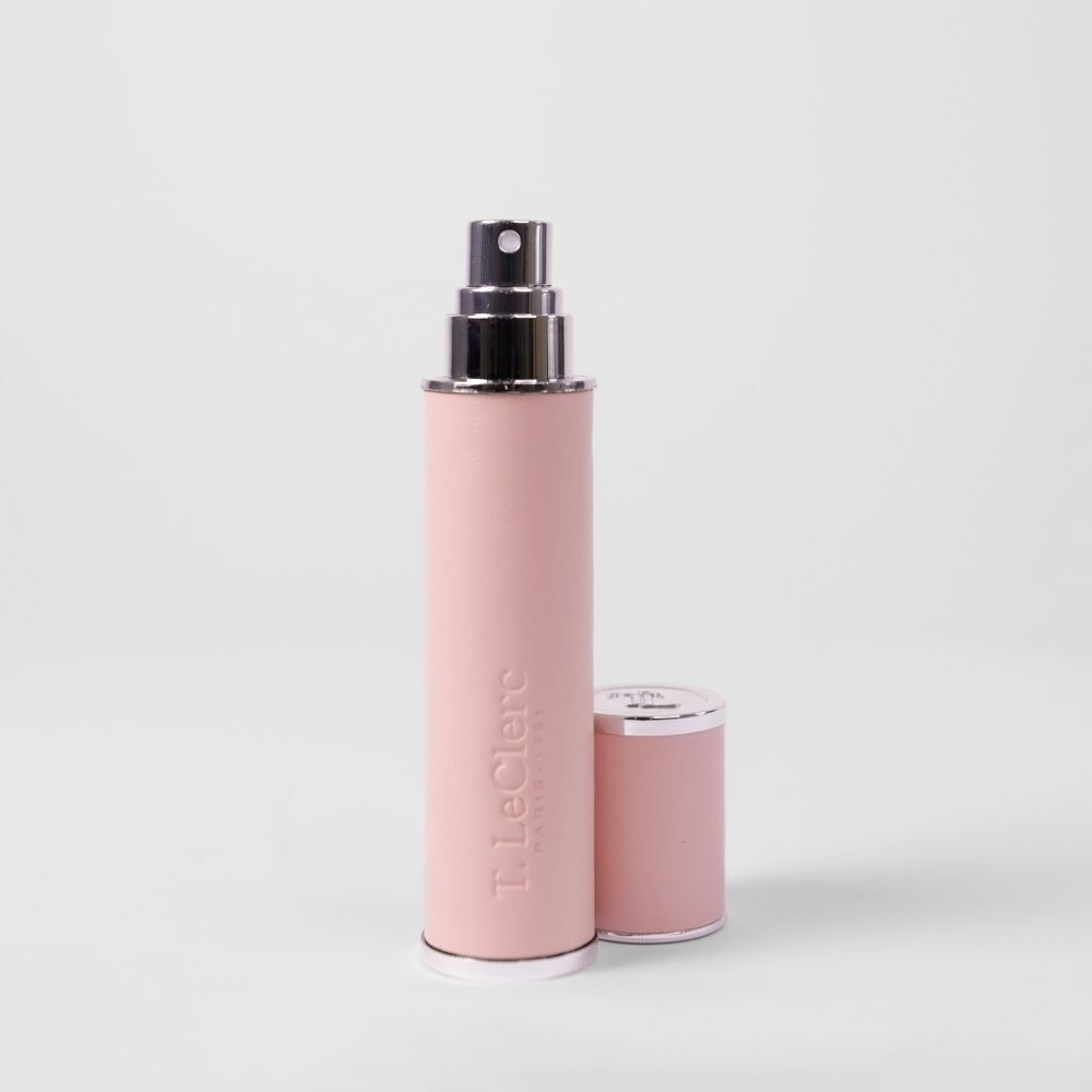 Un vaporisateur de parfum T. LeClerc rose avec un capuchon argenté.